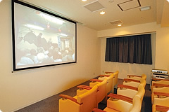 映像鑑賞・講演会などで使用されるシアタールーム。木製の椅子が整然と並ぶ